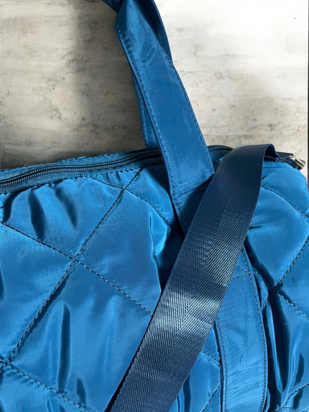 Sac polochon matelassé bleu avec anses et bandoulière réglable