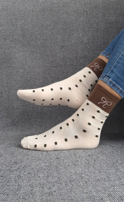 Paire de chaussettes beige en coton à pois noir avec bordure marron et motif nœud blanc