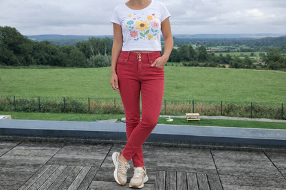 Femme portant un jean skinny taille haute rouge brique de la marque Le Petit Placard, avec un t-shirt floral, vue de face.