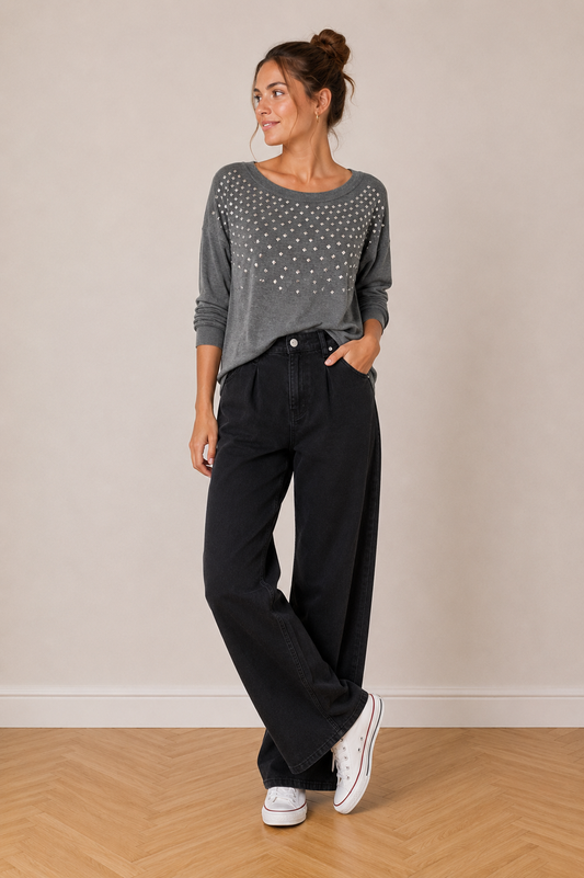 Pull Fin Gris – Clous Pyramidaux Argentés Rock Chic taille M: femme portant haut gris à motifs étoiles et jean noir large, sneakers blanches.