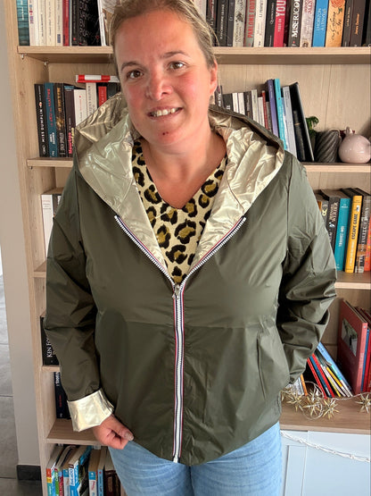 Imperméable réversible kaki/doré porté par une femme dans une bibliothèque, col et ourlet dorés, zippé, veste légère Laura Jo.
