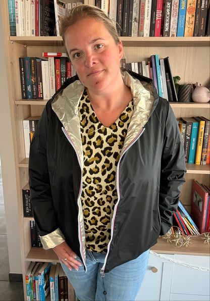Imperméable réversible Laura Jo noir/doré, porté par une femme, intérieur et col doré visibles, posé en librairie. Léger, taille généreuse.