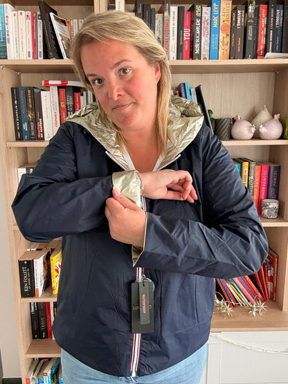 Imperméable Réversible Court Bleu Marine Doré Femme Laura Jo Mi Saison : femme porte veste bleue réversible avec doublure dorée, essayant le zip devant.