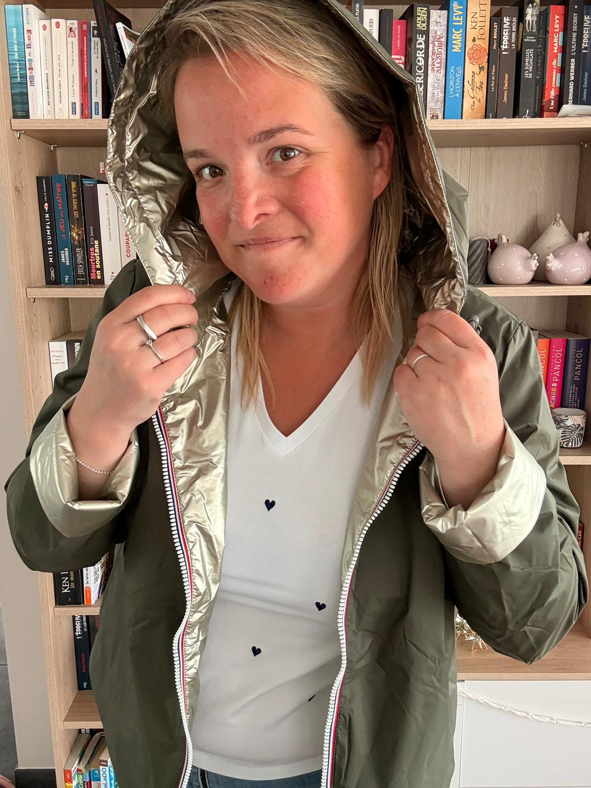 Imperméable réversible court kaki doré femme Laura Jo Mi-Saison portée par une femme, en intérieur, près d’une bibliothèque.