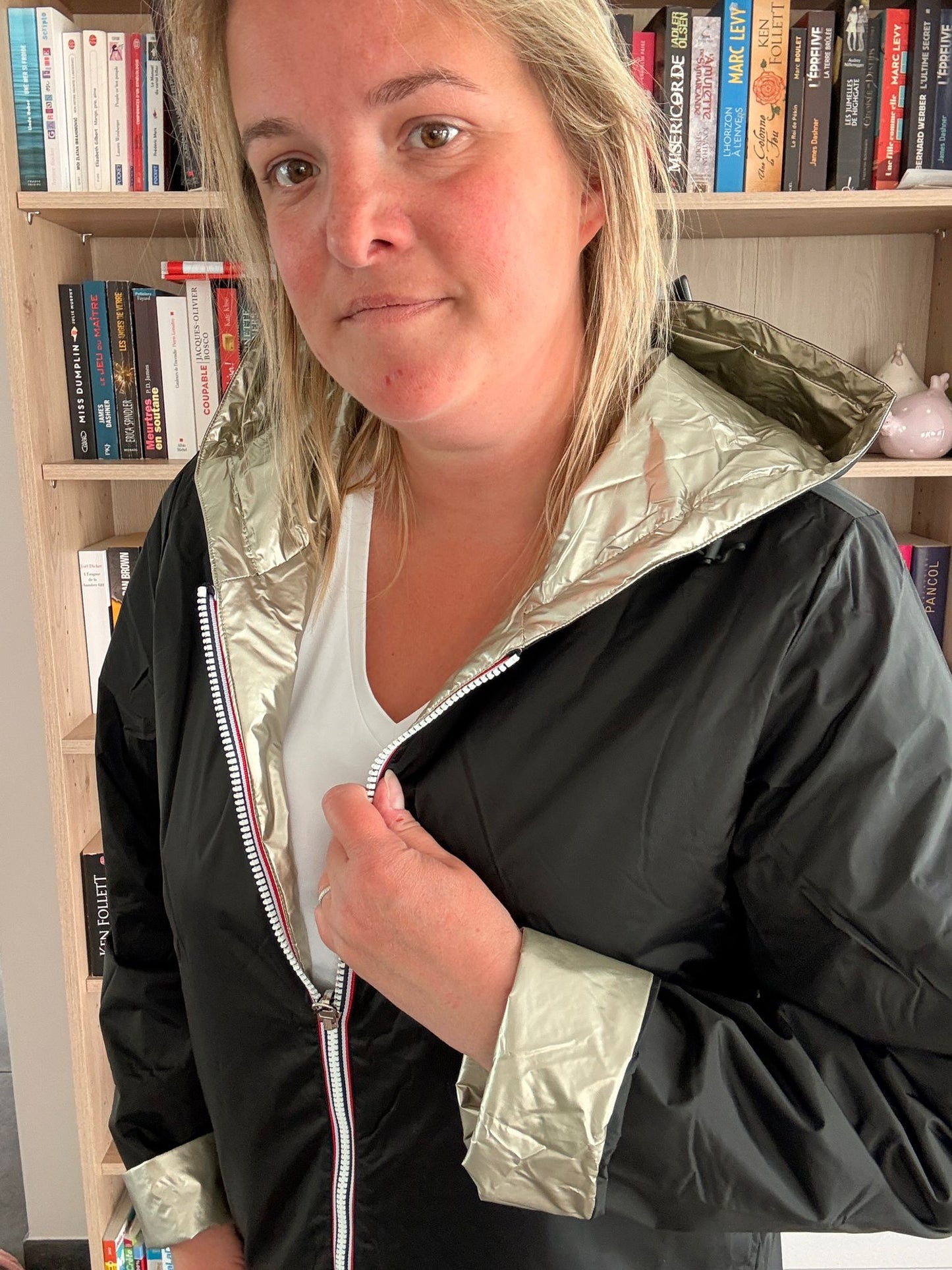 Imperméable réversible court noir doré femme Laura Jo Mi-Saison, vue portée par une femme en intérieur.