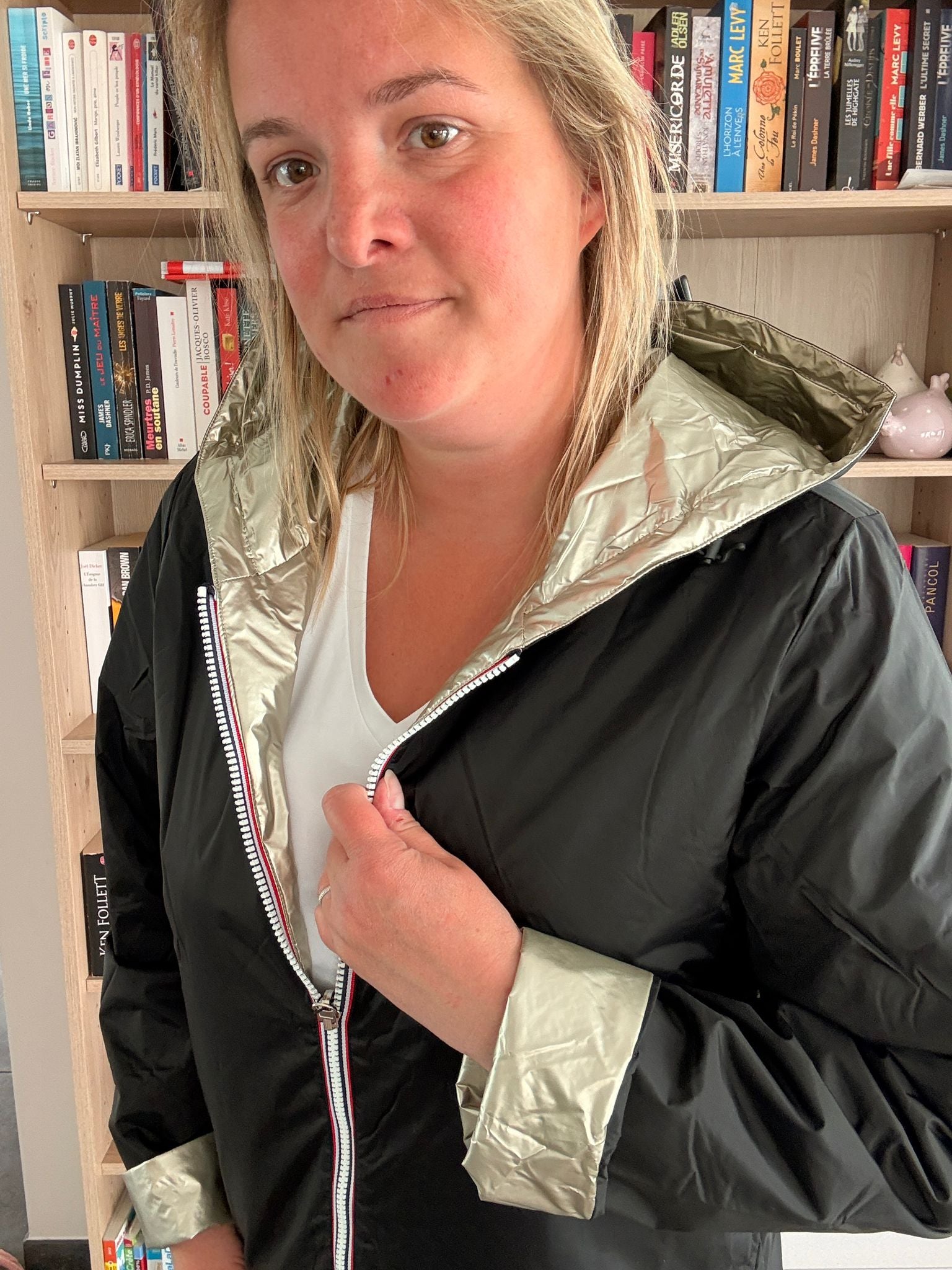 Imperméable réversible court noir doré femme Laura Jo Mi-Saison, vue portée par une femme en intérieur.