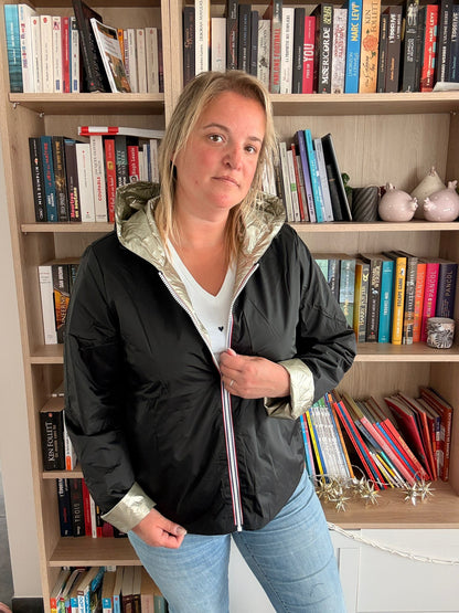 Imperméable réversible court noir doré pour femme, portée par une femme dans une bibliothèque.
