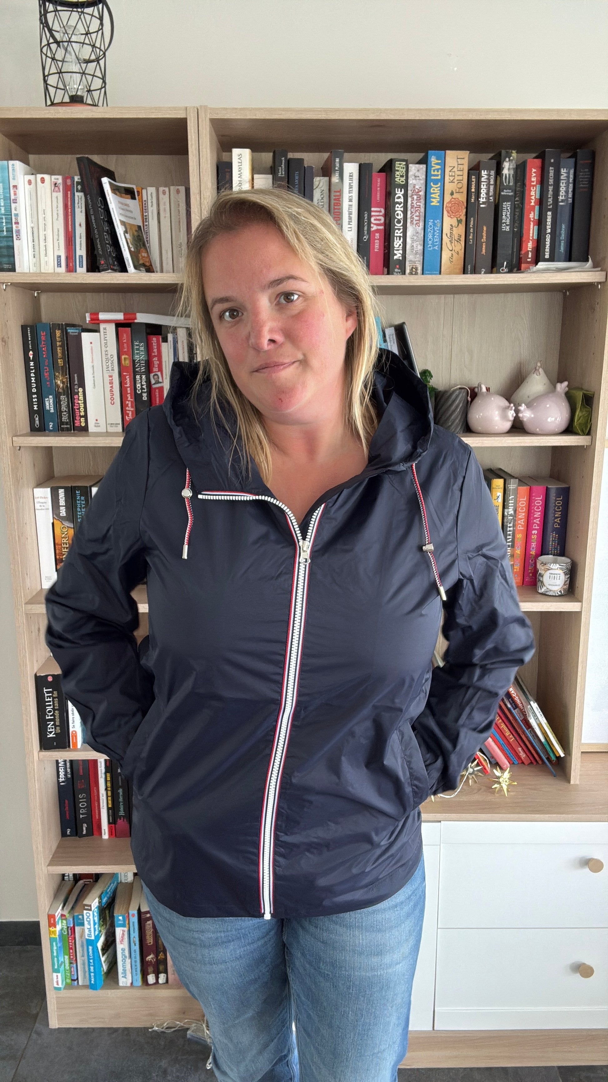 Femme portant l'imperméable mi-long bleu marine Laura Jo fermé, coupe droite mi-longue, zip tricolore et capuche dans le dos