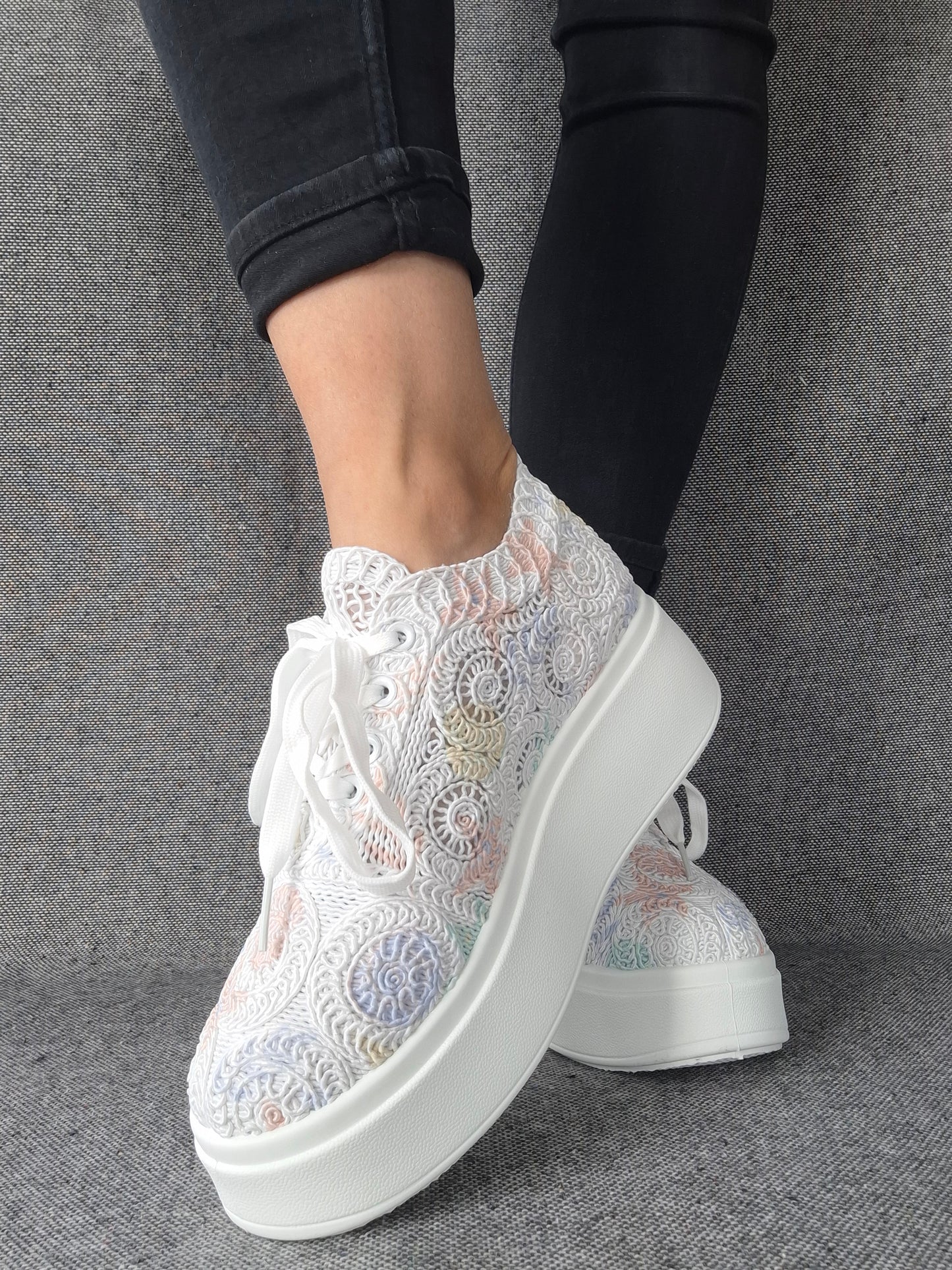 Sneakers plateforme dentelle brodée irisée aux reflets multicolores pastel, portées avec un jean noir