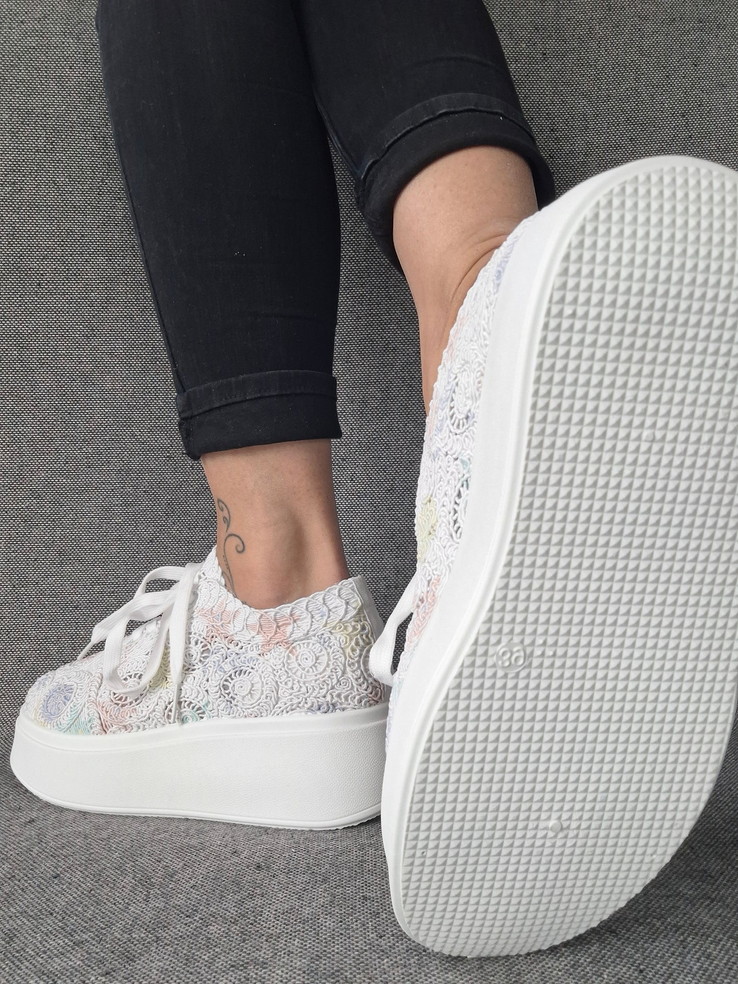 Sneakers plateforme dentelle brodée irisée aux reflets multicolores portées avec un jean noir, semelle blanche structurée