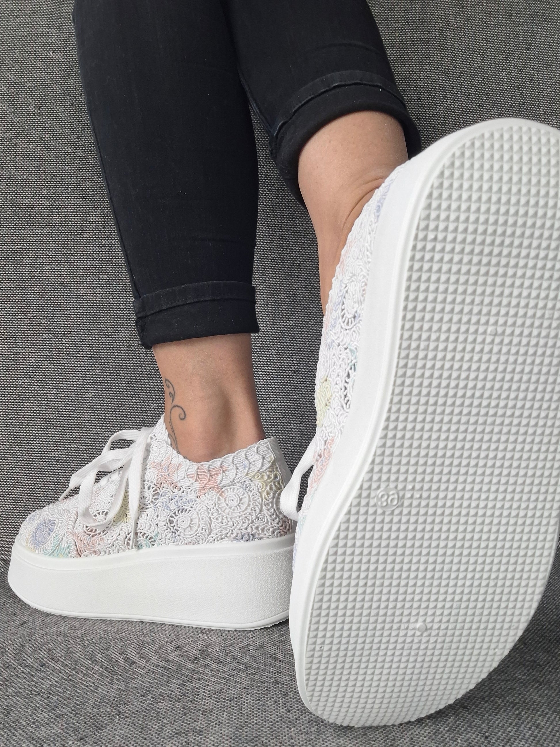 Sneakers plateforme dentelle brodée irisée aux reflets multicolores portées avec un jean noir, semelle blanche structurée