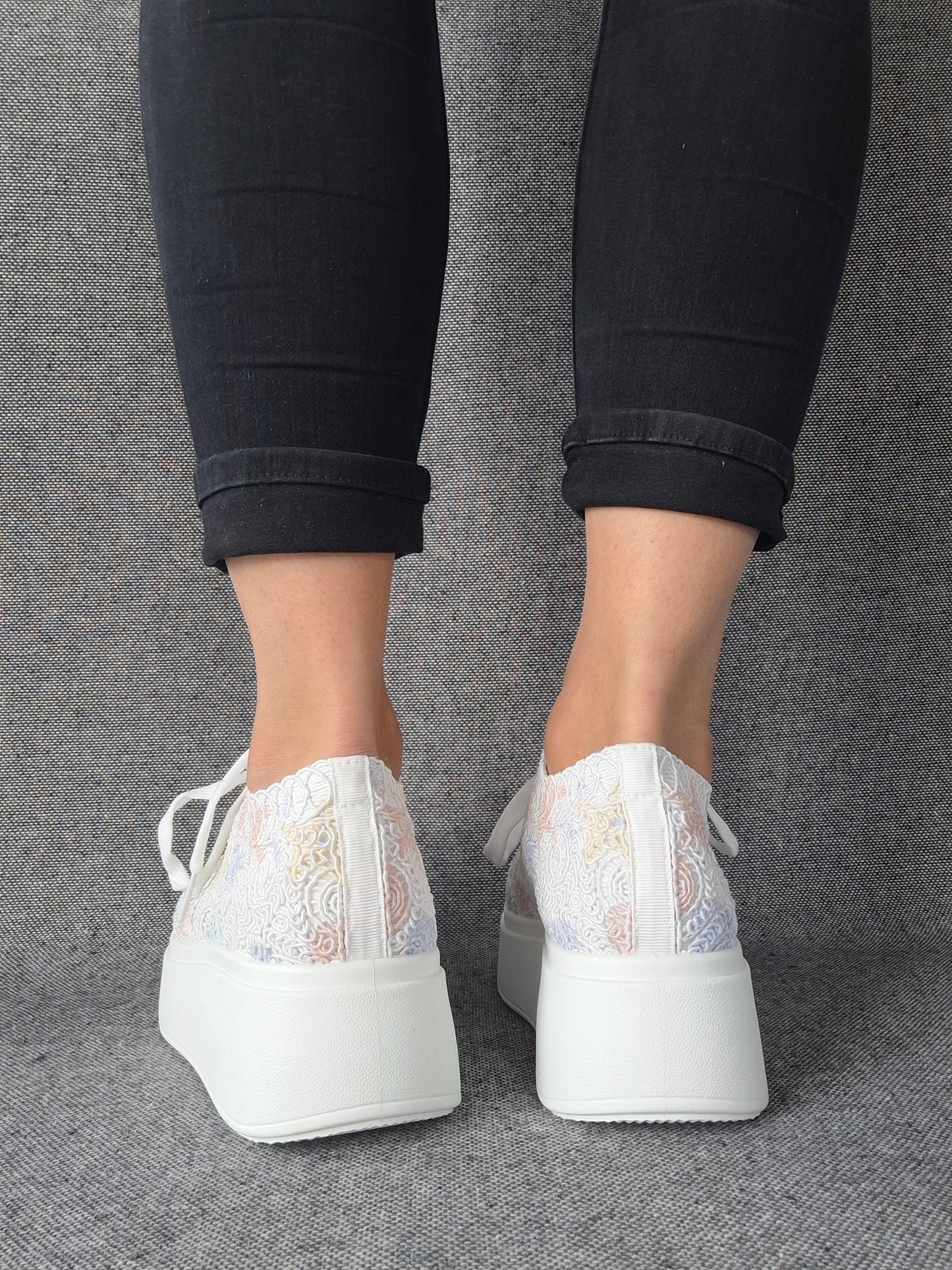 Vue arrière de sneakers plateforme dentelle brodée irisée blanche aux reflets multicolores portées avec un jean noir