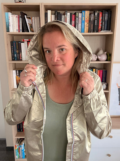 Femme portant la parka dorée Laura Jo avec capuche relevée et zip fermé, vue frontale
