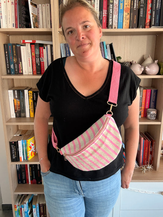 Sac banane rayé rose et blanc porté en bandoulière croisée – vue de face légèrement de côté