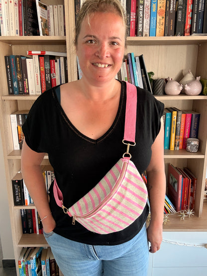 Femme portant un sac banane rayé rose et beige avec bretelle rose réglable – plan moyen