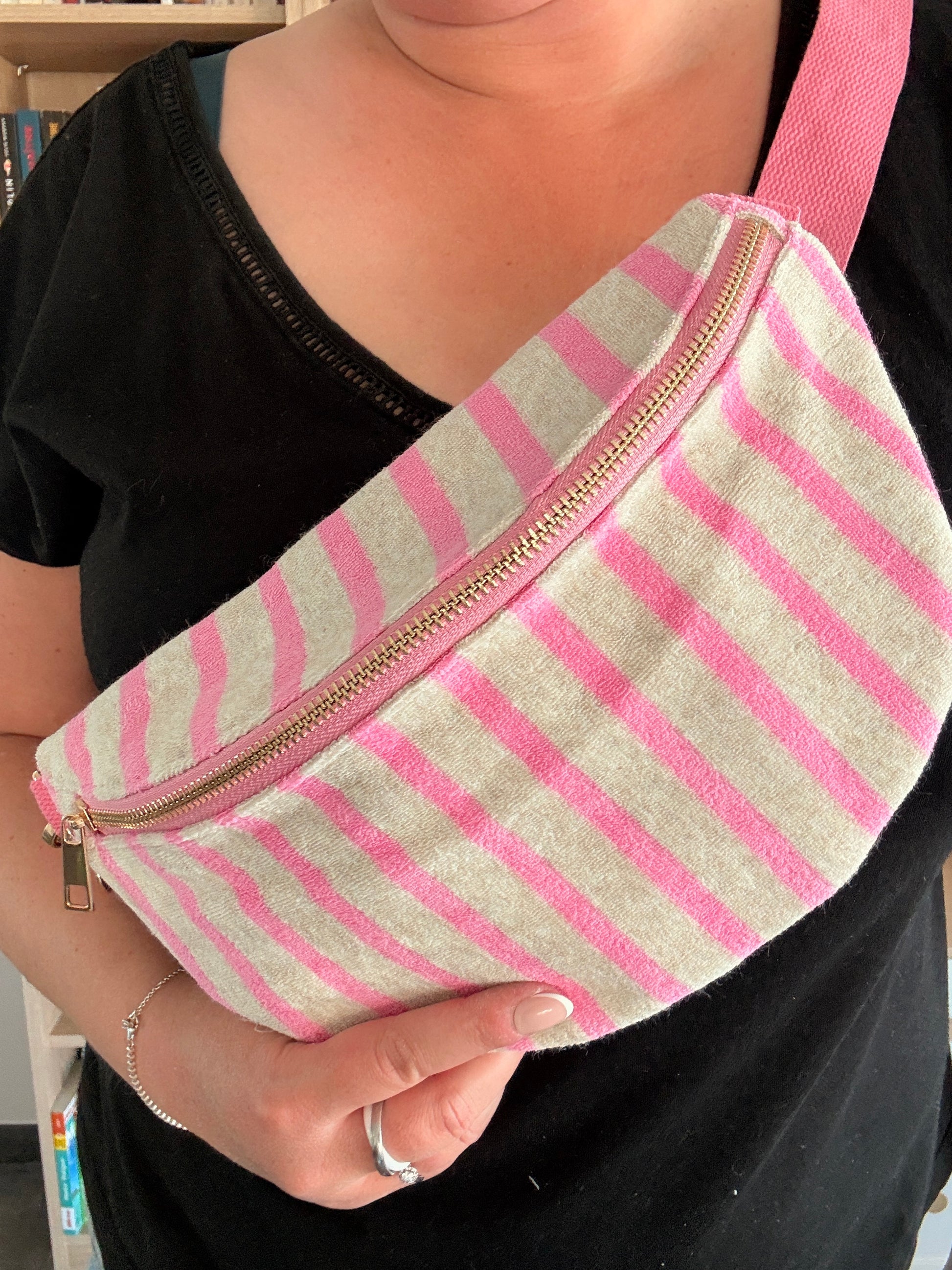 Gros plan sac banane tissu rayé rose et blanc avec fermeture éclair dorée