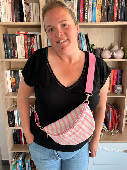 Sac banane rayé rose porté en bandoulière – détail bretelle et mousqueton doré