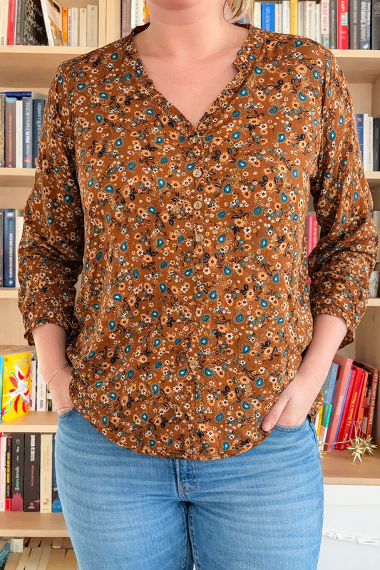 Blouse florale caramel avec col V et volant, en tissu léger, de la marque Le Petit Placard, portée avec style.