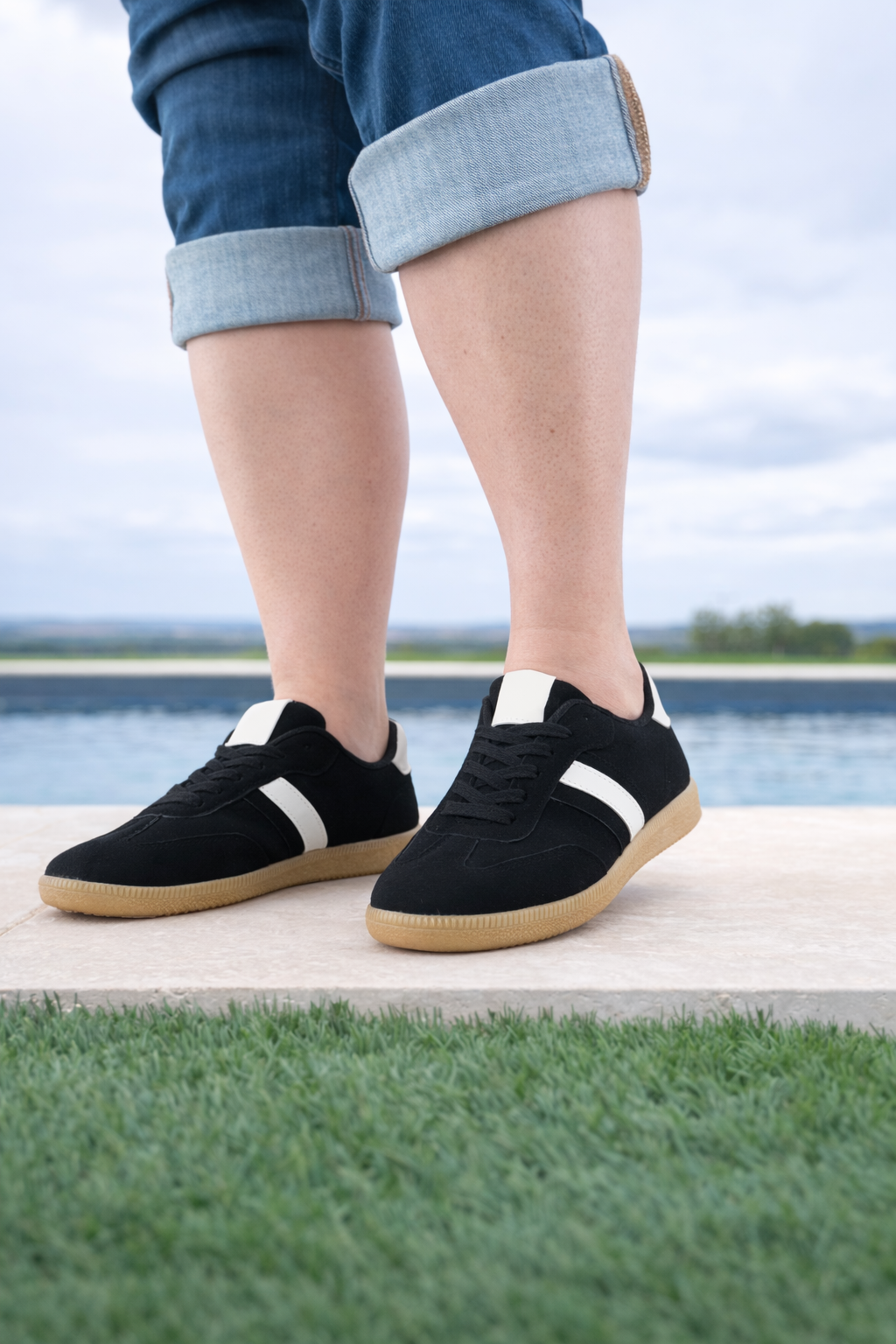 Baskets basses noires bande blanche femme style sneakers campus portées avec un jean, semelle caoutchouc naturel