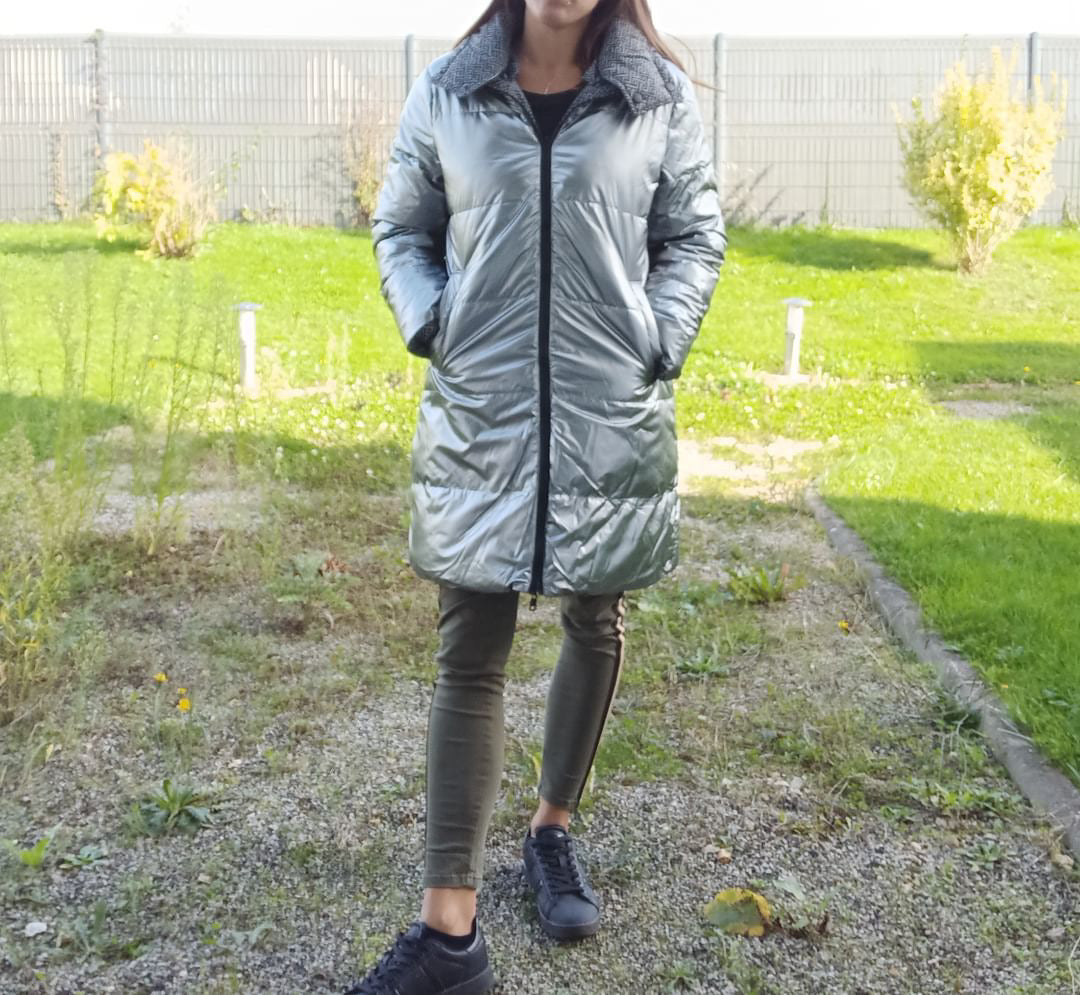 Woman wearing long grey reversible quilted waterproof coat outdoors, Le Petit Placard