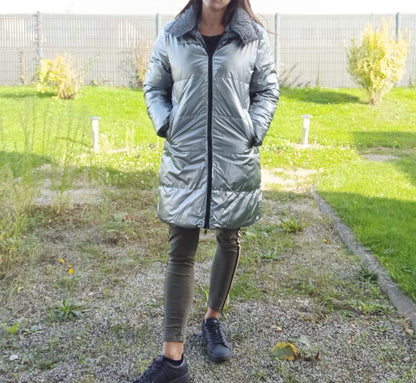 Woman wearing long grey reversible quilted waterproof coat outdoors, Le Petit Placard