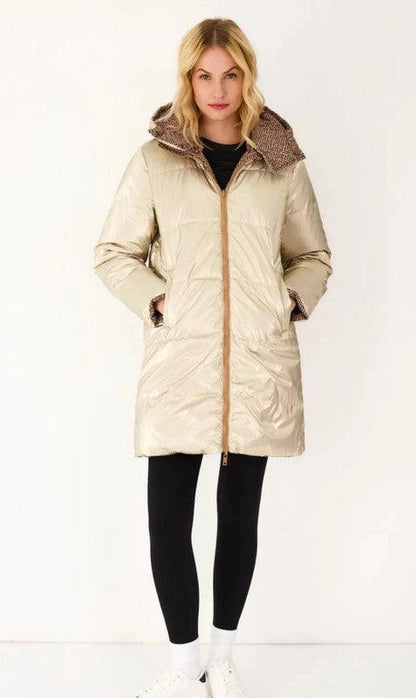 Woman in a gold reversible waterproof puffer coat from Le Petit Placard, hands in pockets