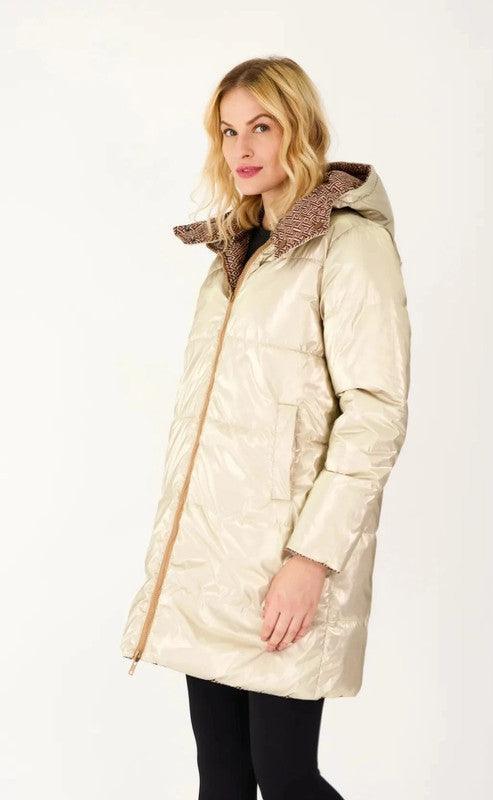Woman wearing long reversible gold quilted waterproof coat from Le Petit Placard