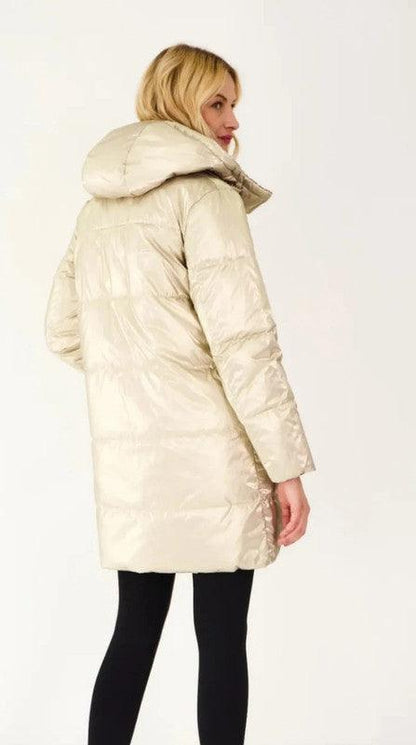 Woman wearing a long reversible gold quilted waterproof coat from Le Petit Placard
