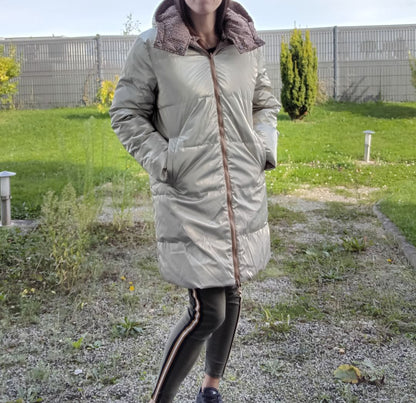 Woman wearing a long reversible waterproof brown puffer coat outdoors, Le Petit Placard