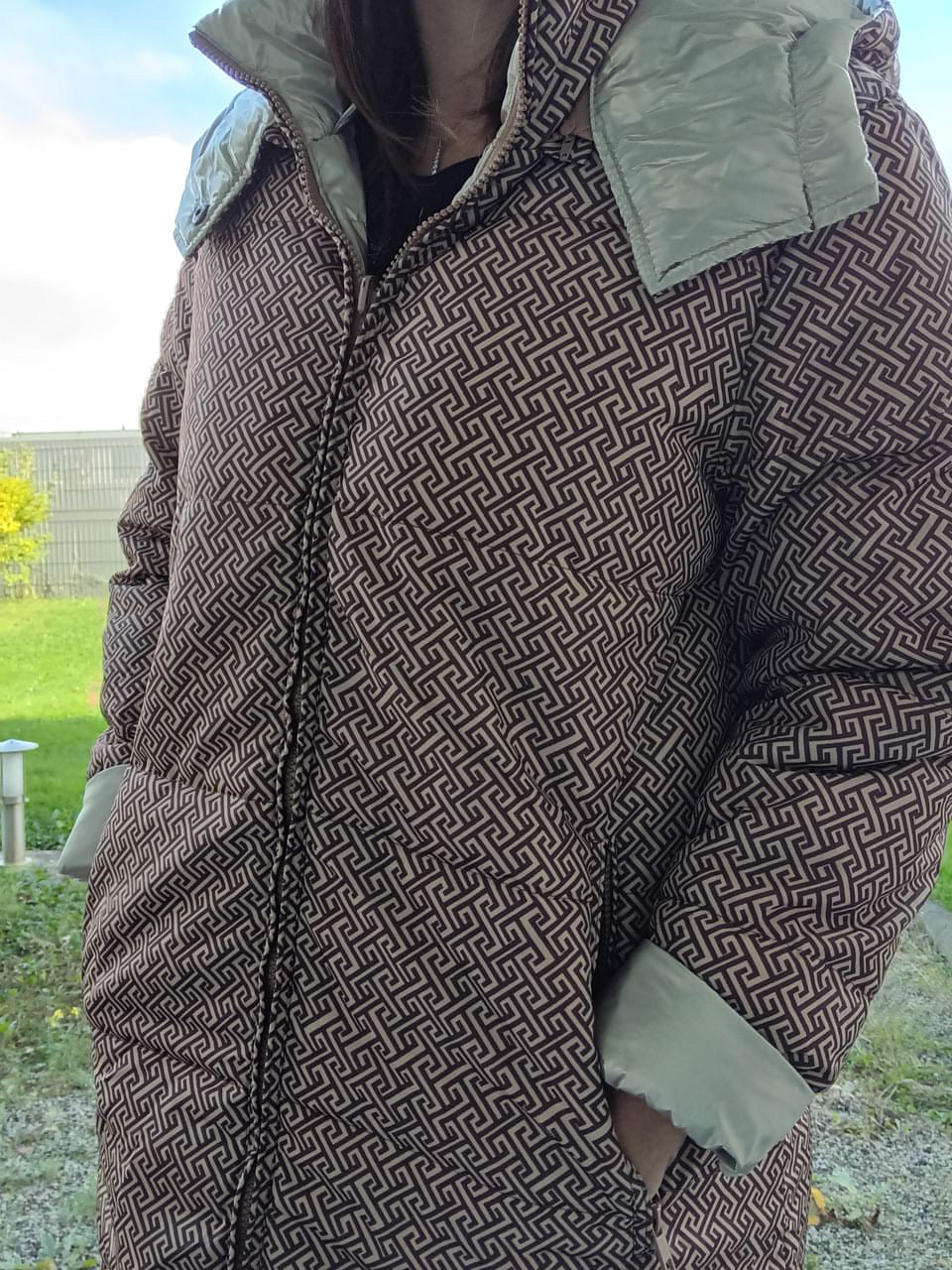 Long reversible brown quilted raincoat with geometric pattern, outdoor setting, Le Petit Placard
