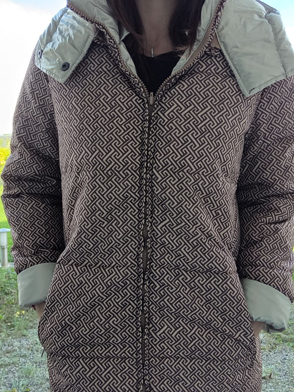 Woman wearing reversible brown and gold quilted waterproof coat from Le Petit Placard