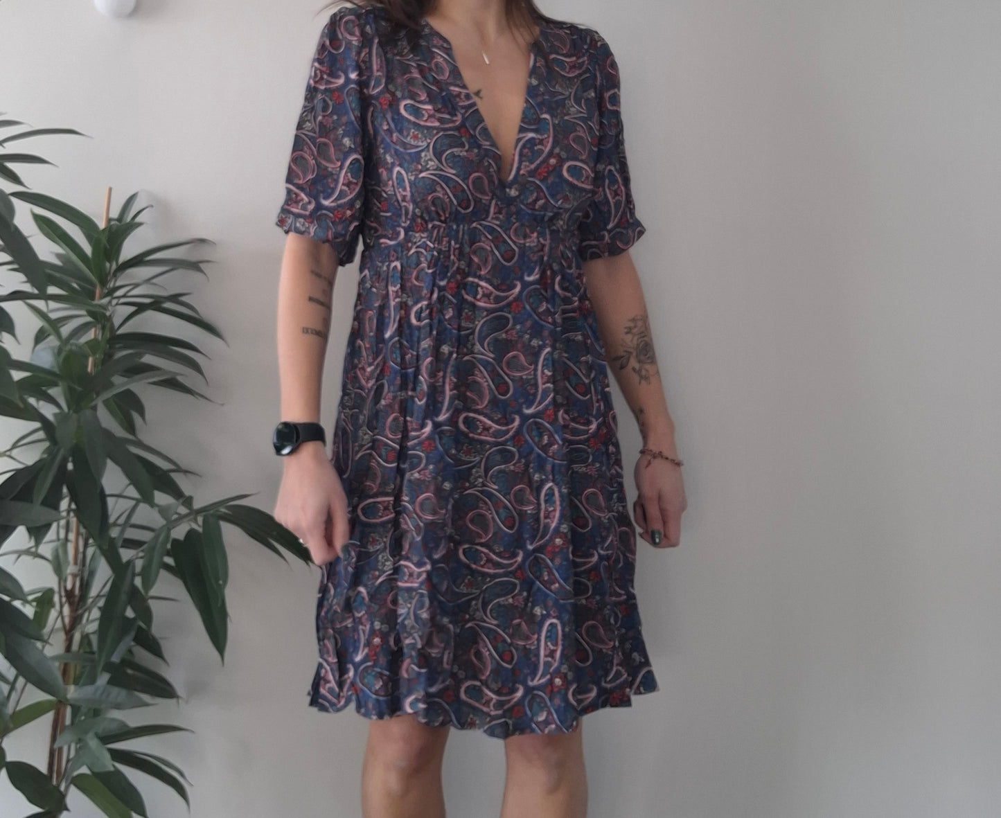 Woman wearing a paisley print short dress indoors, trendy fashion from Le Petit Placard.