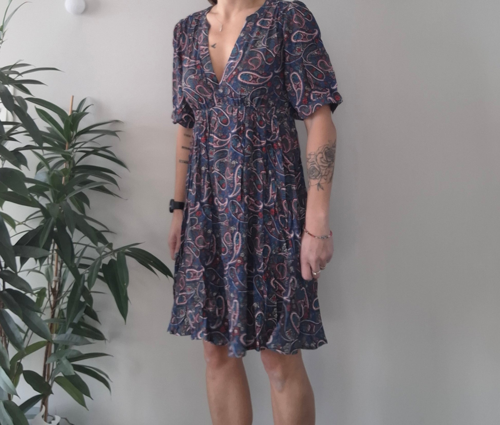 Woman wearing paisley print midi dress standing by indoor plant, Le Petit Placard fashion