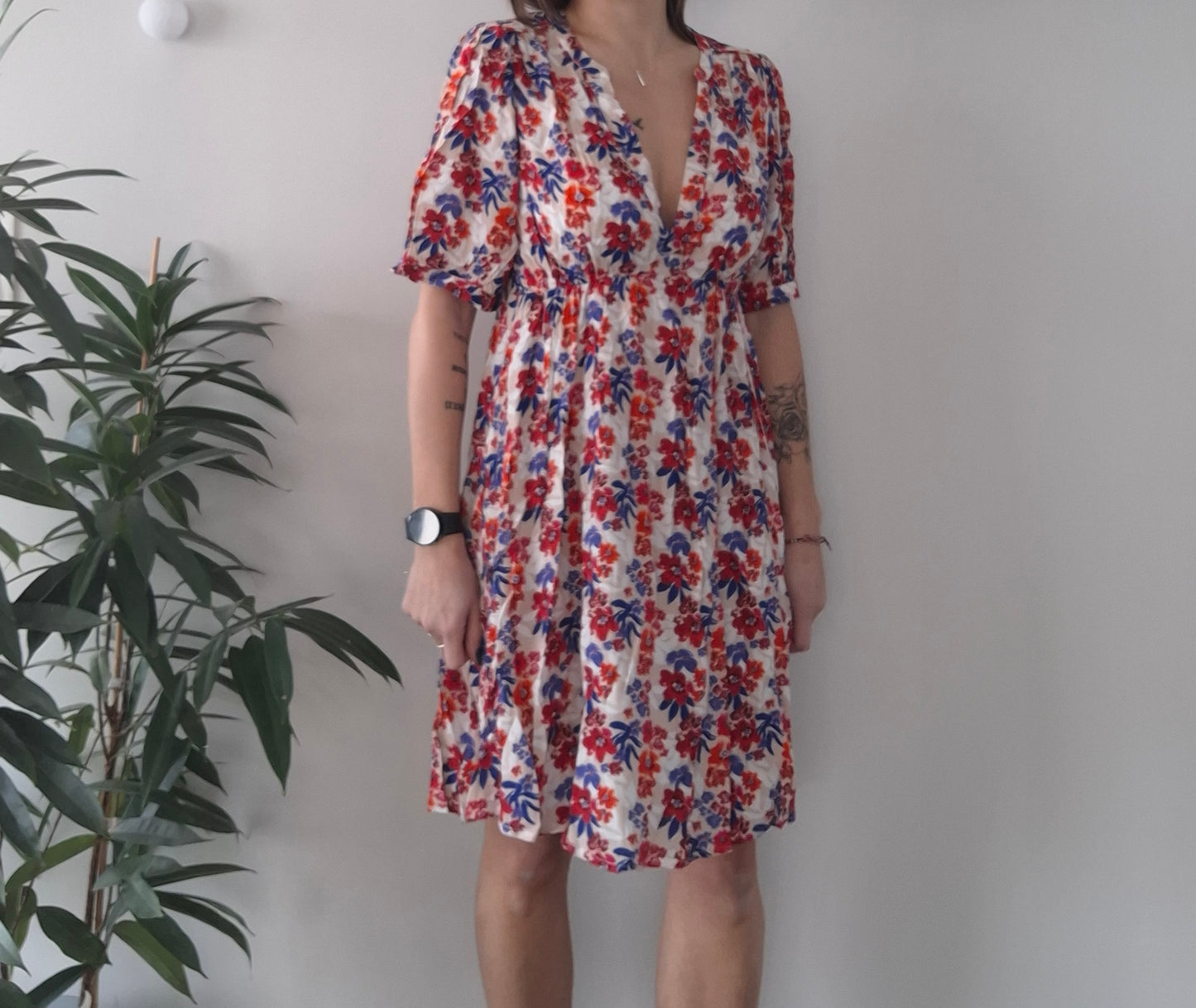 Woman modeling short-sleeve floral dress with red and blue print, Le Petit Placard fashion