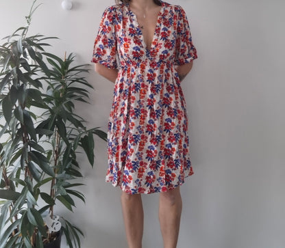 Woman wearing a floral summer dress with red and blue flowers, Le Petit Placard fashion