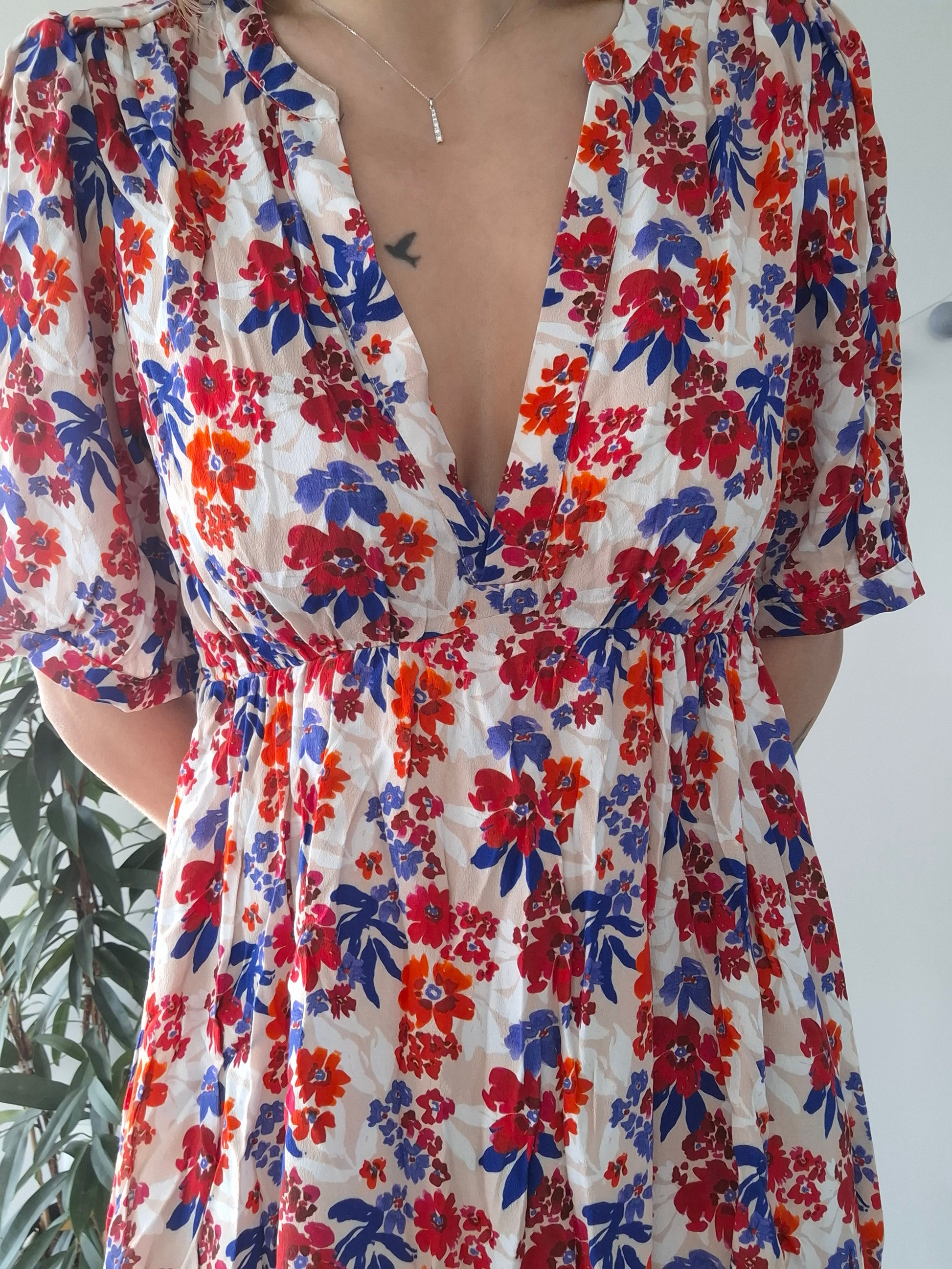 Woman wearing floral dress with red, blue, and orange prints, Le Petit Placard style