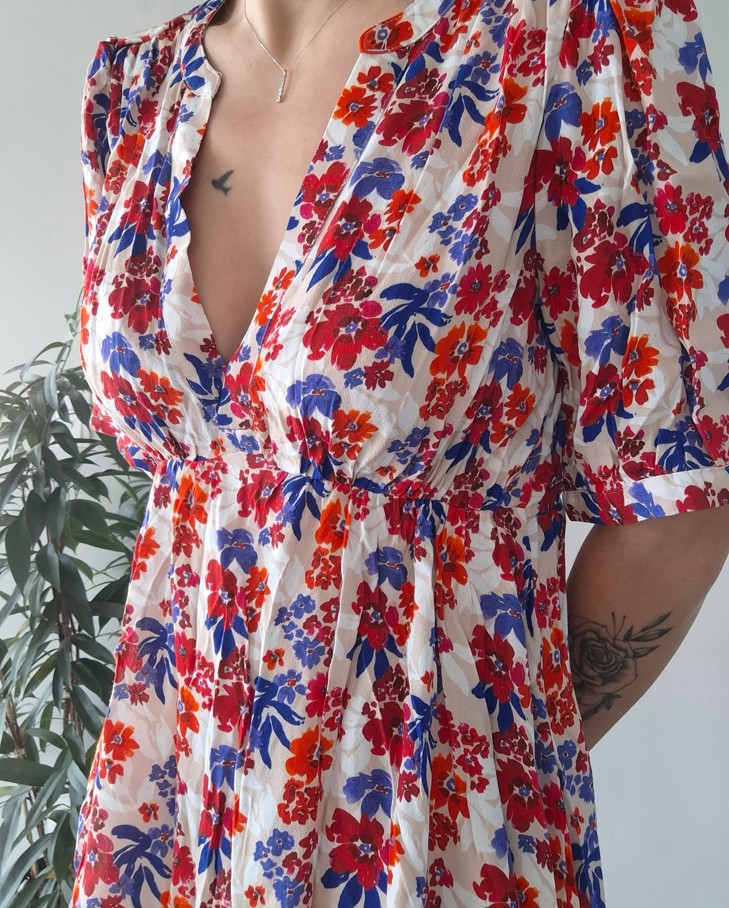 Colorful floral dress with red, blue, and orange flowers, model standing indoors, Le Petit Placard