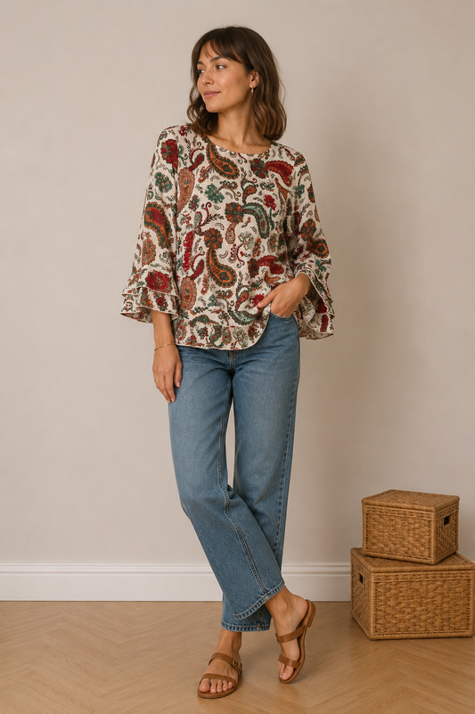 Blouse imprimé paisley ivoire à manches volantées portée avec jeans bleu et sandales marron, vue complète.