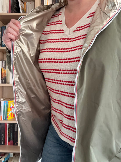 Imperméable kaki Melya Melody ouvert révélant sa doublure dorée brillante, porté par une femme en pull rayé rouge