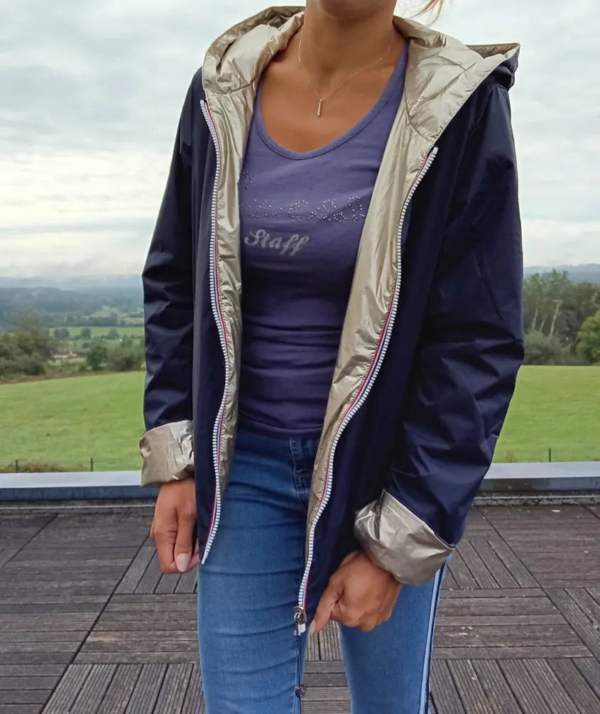 Imperméable réversible court bleu marine doré femme Laura Jo Mi Saison porté en extérieur, capuche et manches visibles.