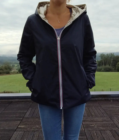 Imperméable réversible court bleu marine doré femme Laura Jo Mi Saison portée en extérieur, avec capuche et fermeture zippée centrale.