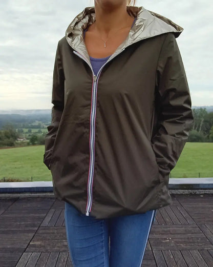 Imperméable réversible court kaki doré pour femme Laura Jo Mi-Saison, ouverte sur une veste à capuche argentée et jean bleu, en extérieur.