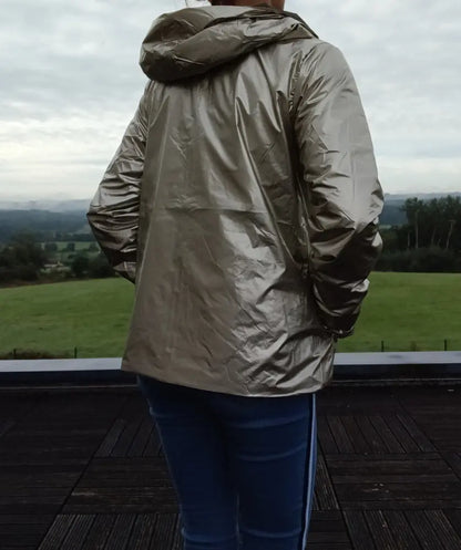 Imperméable réversible court kaki doré femme, vue arrière sur une personne debout sur une terrasse avec paysage verdoyant.