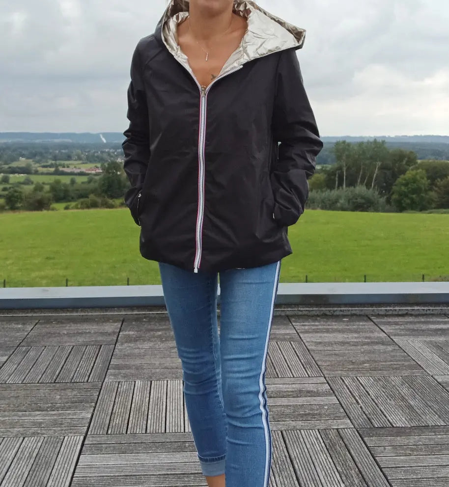 Imperméable réversible court noir doré pour femme, Laura Jo Mi-Saison, portée ouverte sur jeans bleu avec liseré blanc sur la jambe.