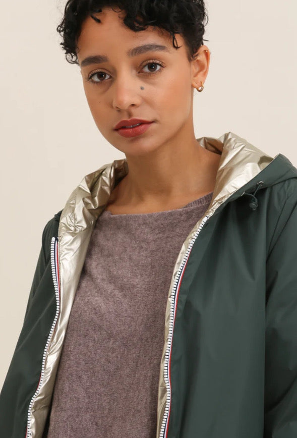 Veste imperméable réversible vert forêt / doré, coupe courte avec capuche, fermeture éclair centrale à rubans tricolores, doublure sombre, manches pliées Laura Jo
