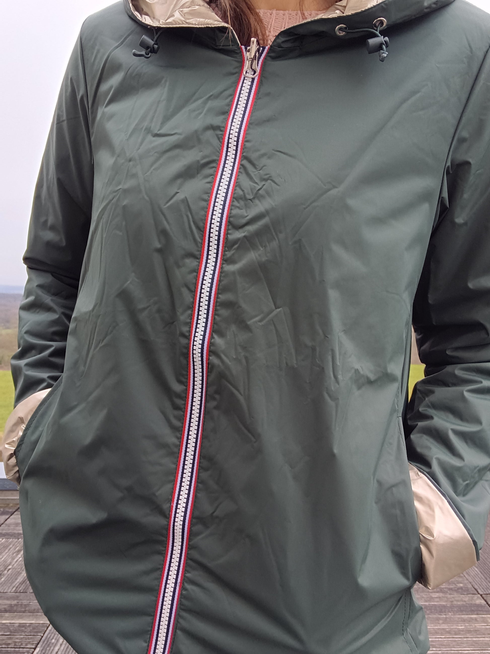 Imperméable réversible vert forêt avec doublure beige, fermeture éclair centrale décorative et capuche ajustable. Manteau mi-saison femme Laura Jo.