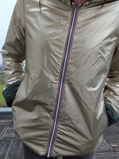Veste imperméable réversible vert forêt / doré, coupe courte avec capuche, fermeture éclair centrale à rubans tricolores, doublure sombre. Laura Jo