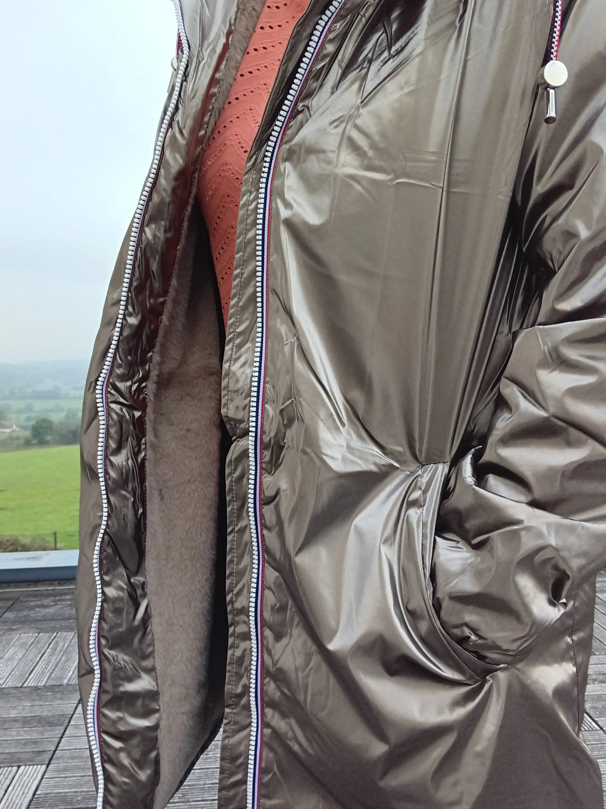 Shiny bronze Laura Jo waterproof jacket with zip detail, showcased outdoors