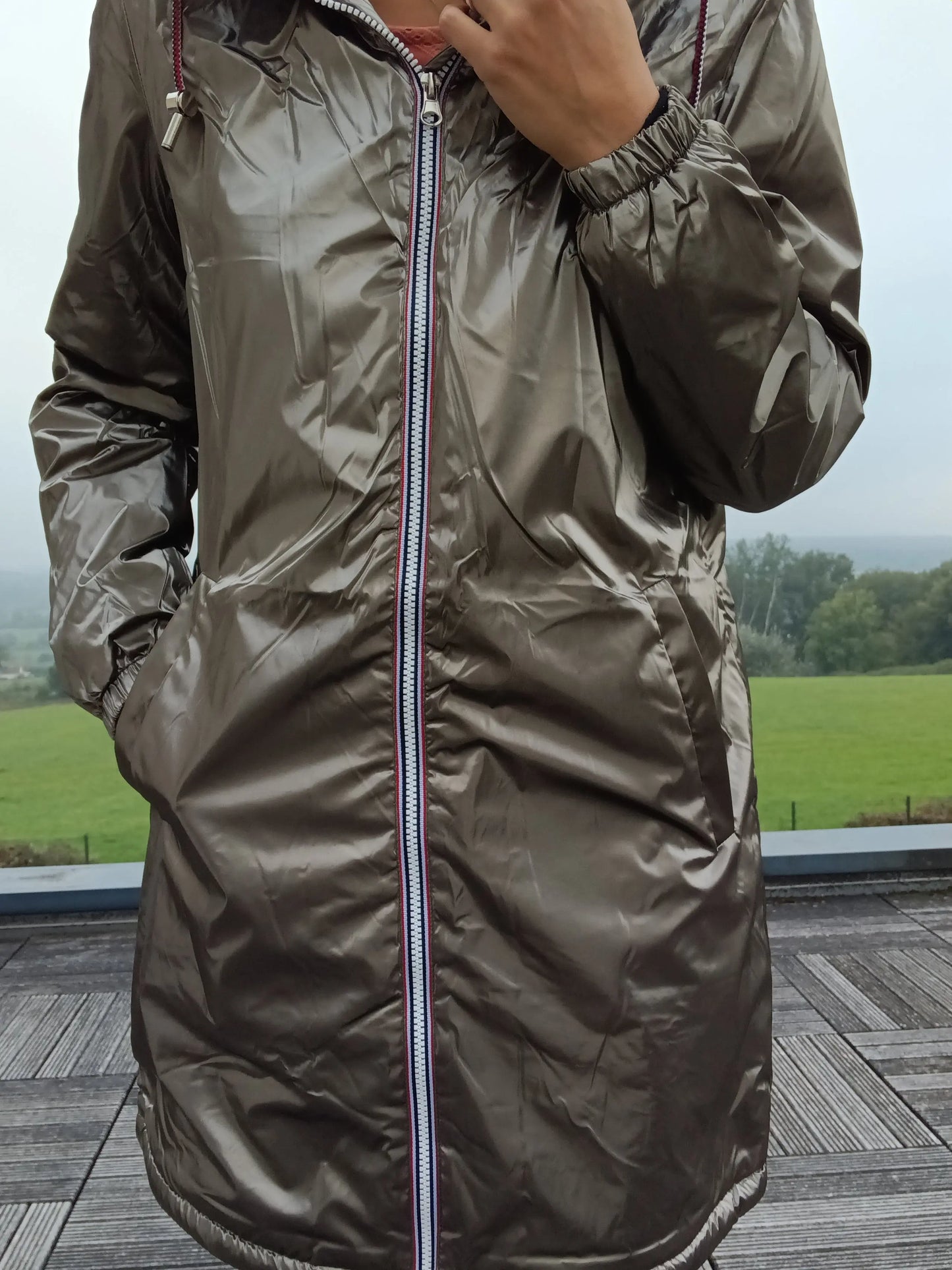 Shiny bronze Laura Jo raincoat with striped zipper, outdoor setting, Le Petit Placard
