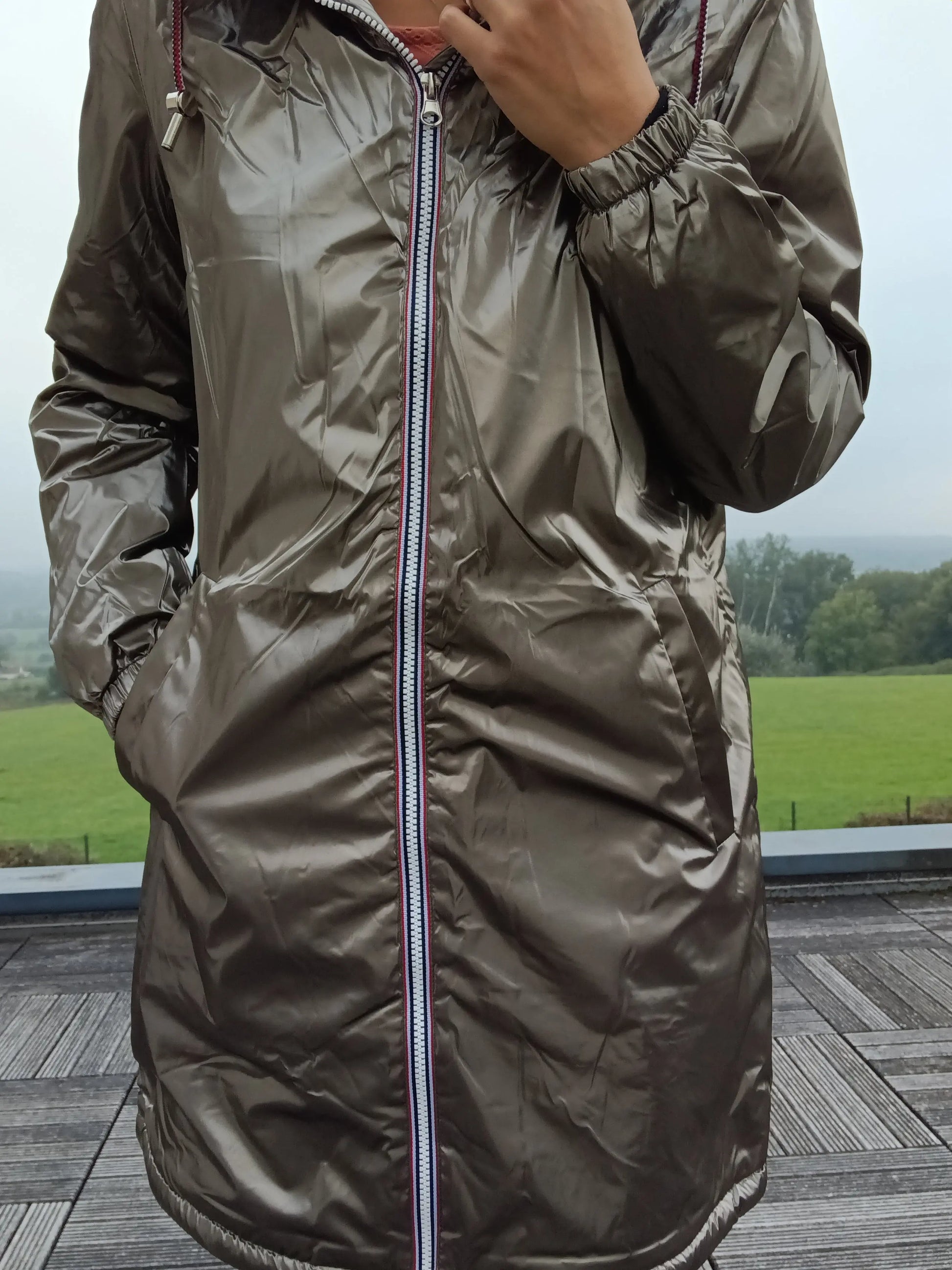 Shiny bronze Laura Jo raincoat with striped zipper, outdoor setting, Le Petit Placard